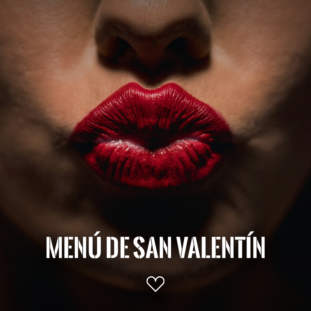Nahaufnahme roter Lippen, die sich küssen, vor dunklem Hintergrund; unten der Schriftzug MENÚ DE SAN VALENTÍN und ein kleines Herz.