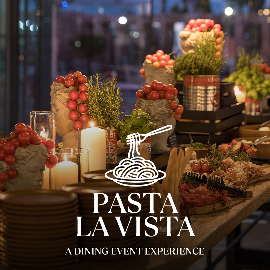 Pasta-Station mit Tomaten, Rosmarin und Kerzen, Kräuter-Deko; Logo PASTA LA VISTA im Vordergrund.